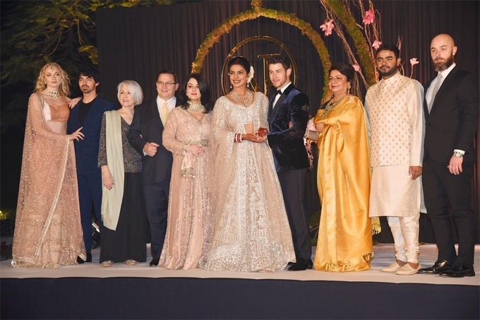Nữ diễn viên người Anh diện trang phục truyền thống Ấn Độ đứng bên ngoài cùng bên trái